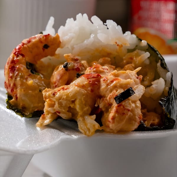 Close-up of a Noble House Hawaiian Restaurant musubi with creamy lobster and white rice.