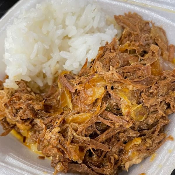 Close-up of Noble House Hawaiian Restaurant's Kalua Pork and Cabbage with a side of white rice.