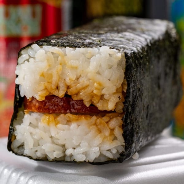 Close-up of a Noble House Hawaiian Restaurant Spam Musubi, with rice, grilled Spam, and nori.